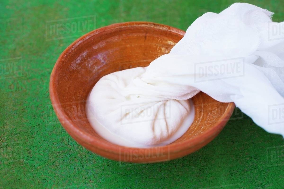 Homemade fresh ricotta in gauze on top of an earthenware dish Stock