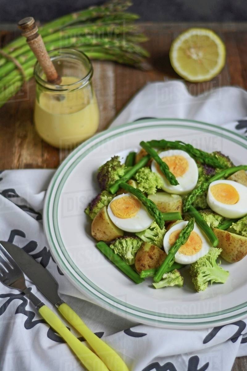 Asparagus salad with potatoes, broccoli, hardboiled eggs and sauce