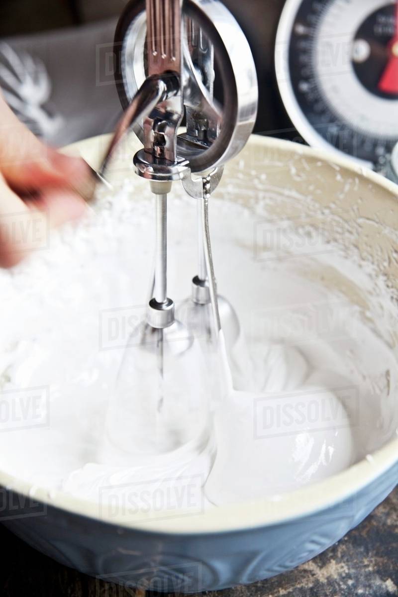 Meringue being beaten with a vintage hand whisk Stock Photo Dissolve
