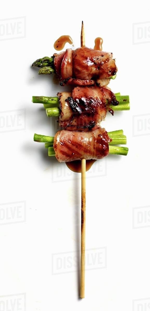 An asparagus and bacon skewer with black pepper teriyaki sauce Stock