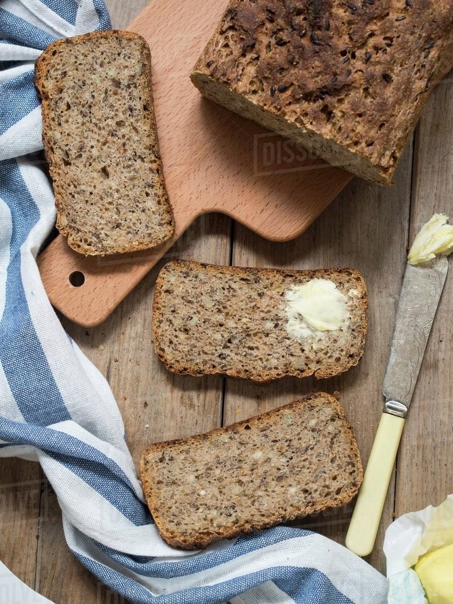 Wholemeal bread with flax seeds and sunflower seeds, one slice spread