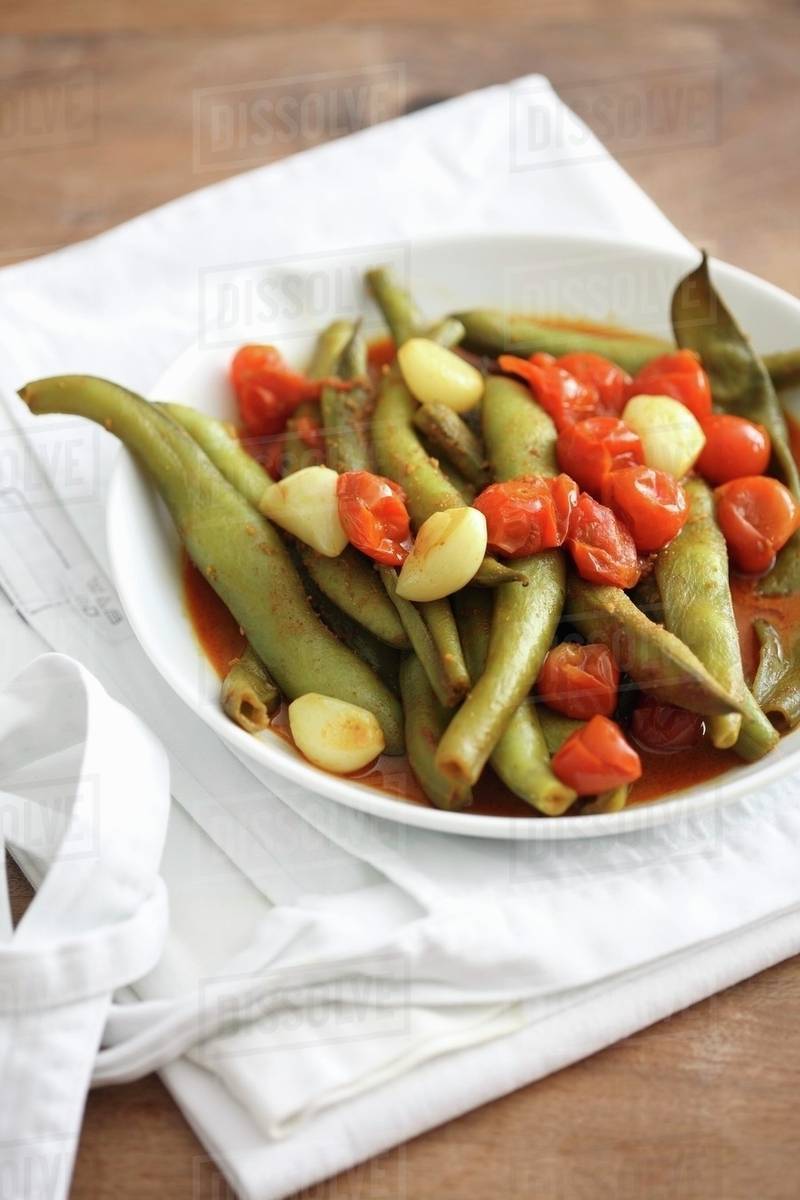 Braised green beans with cherry tomatoes and garlic Stock Photo Dissolve