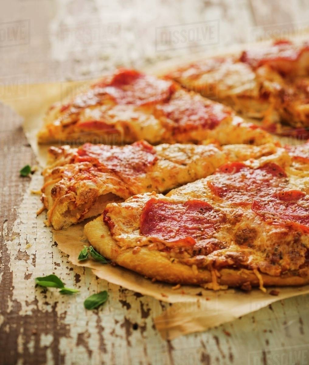 Sliced Pepperoni Pizza on Parchment Paper Stock Photo Dissolve