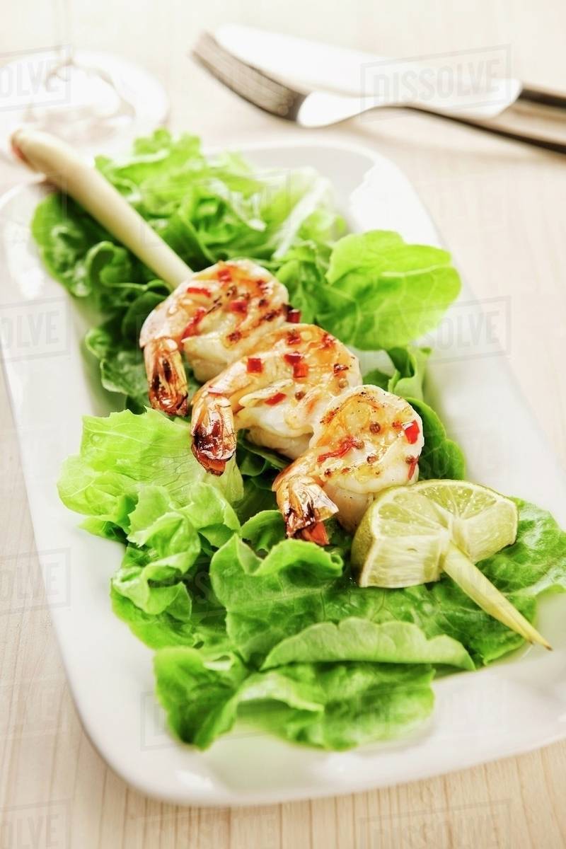 Grilled marinated king prawns on a lemongrass skewer Stock Photo