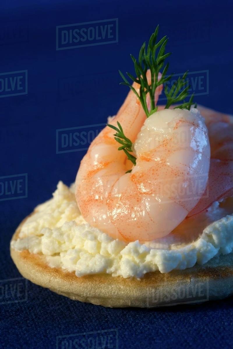 A blini topped with cream cheese and prawns Stock Photo Dissolve