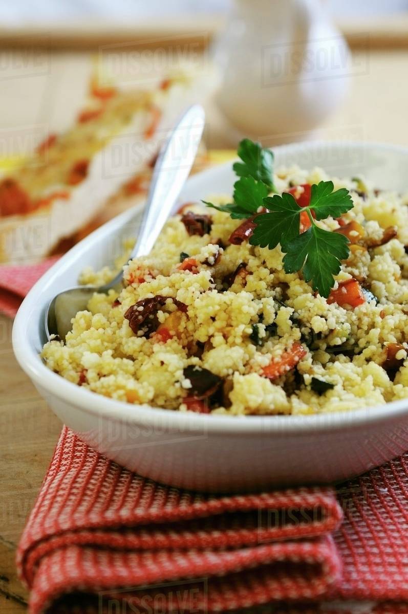 Couscous with dried tomatoes, peppers and courgette Stock Photo