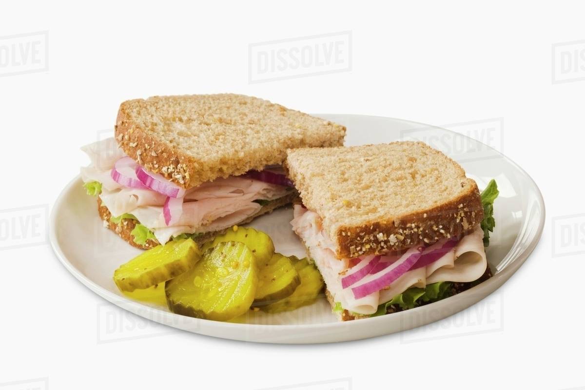 Turkey Sandwich on Wheat Bread; Halved with Pickles Stock Photo