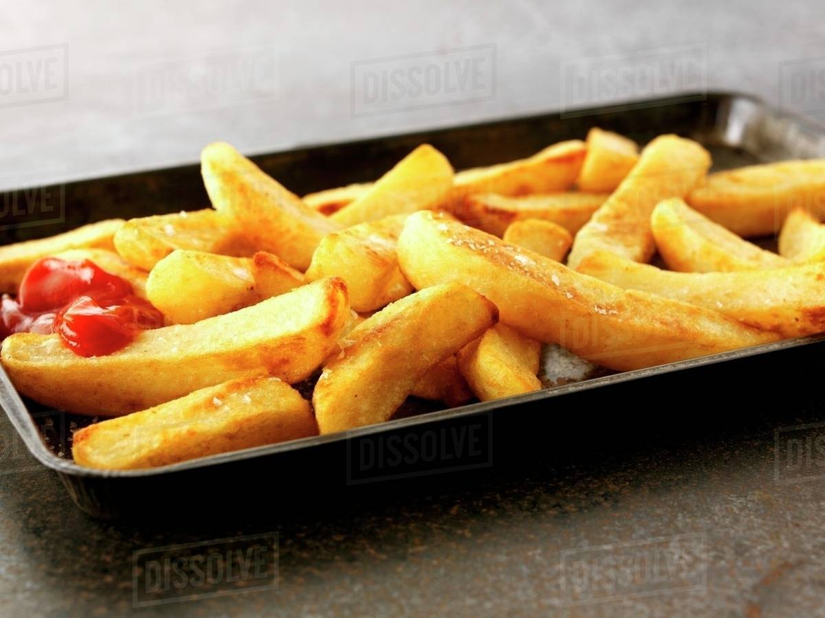 Ketchup on French fries, closeup, elevated view Stock Photo Dissolve