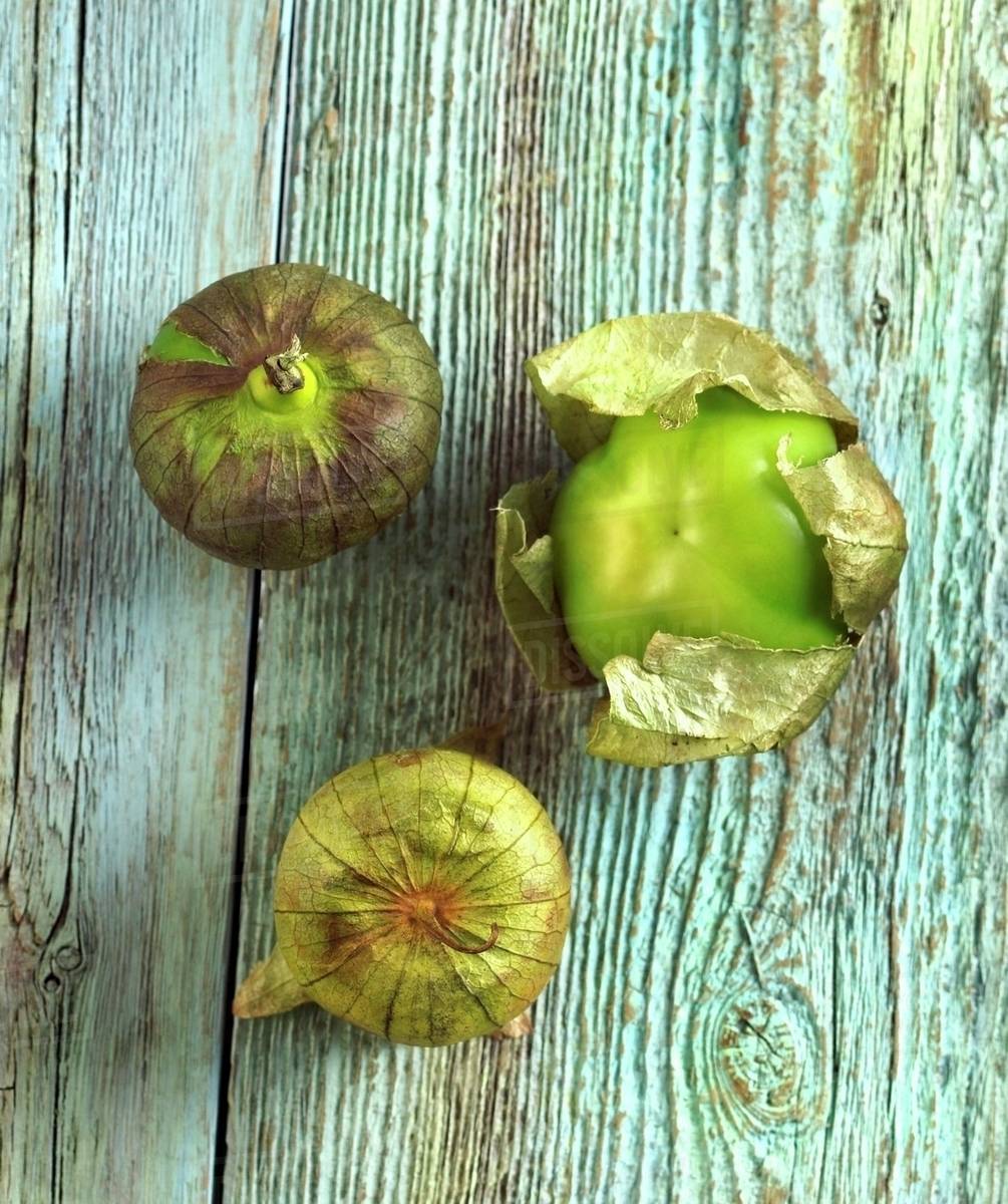 Three Tomatillos on Distressed Wood Stock Photo Dissolve