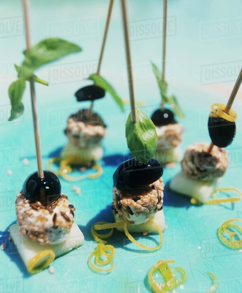 Soft cheese & olives with sesame & basil on cocktail sticks Stock