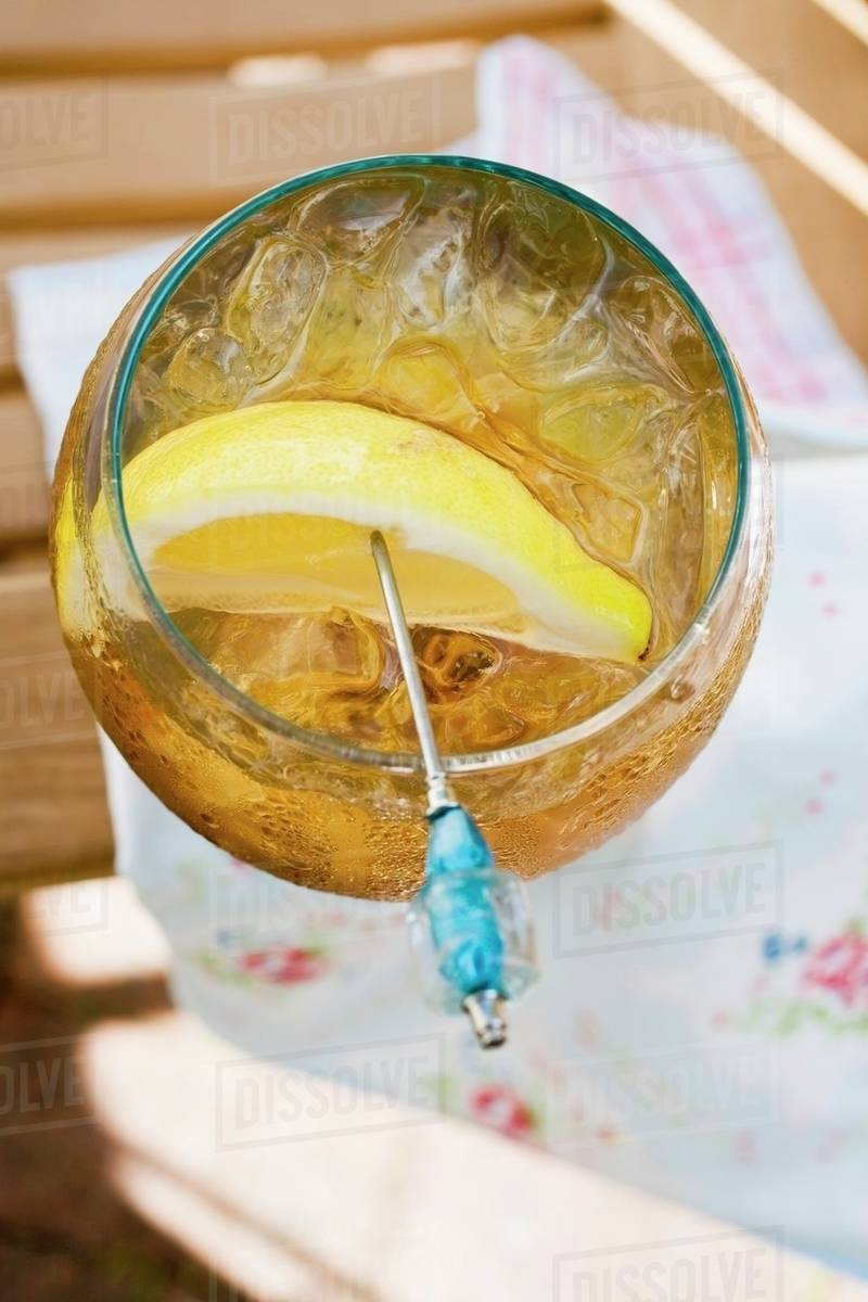 Rum and tonic with ice cubes and lemon wedge Stock Photo Dissolve