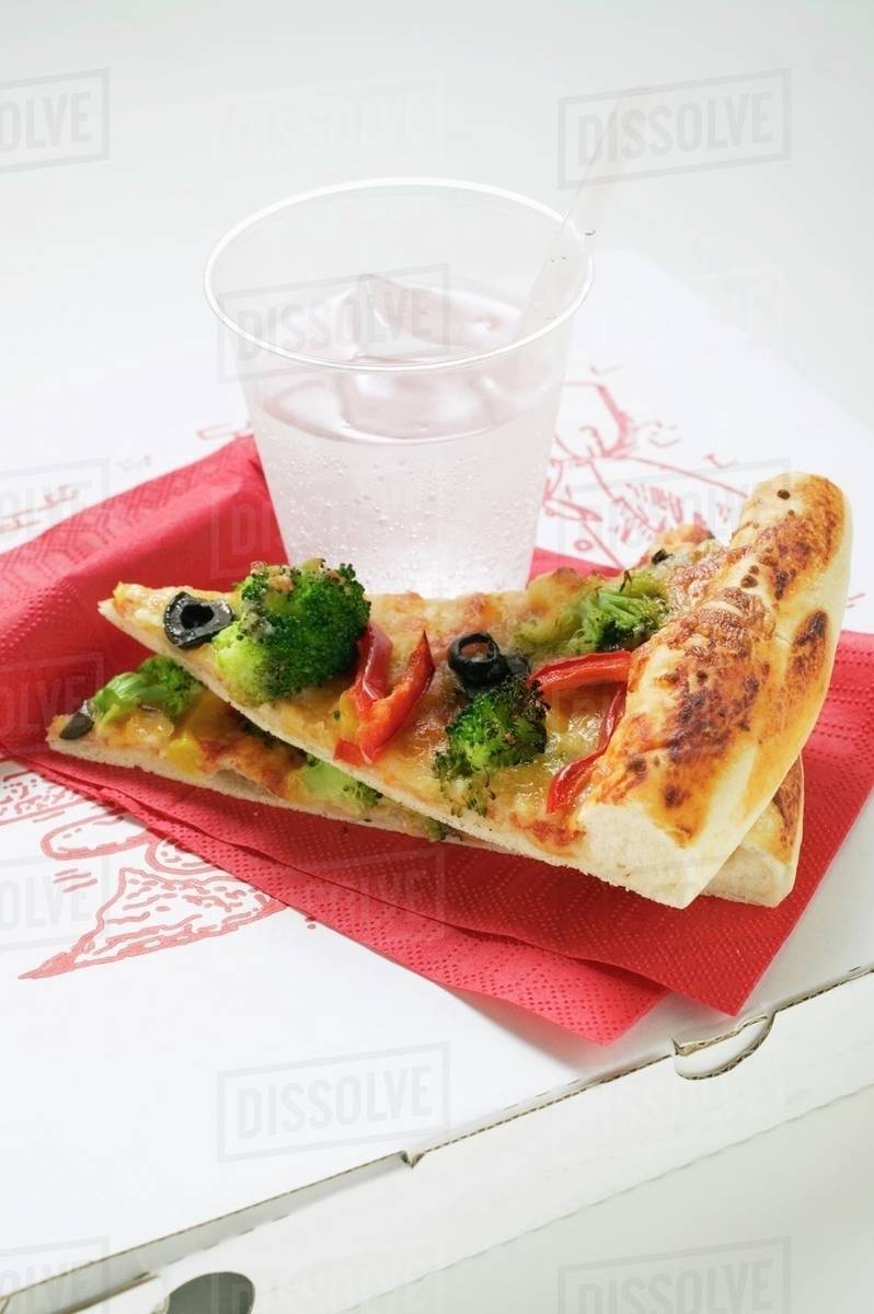 Two slices of Americanstyle vegetable pizza, mineral water Stock