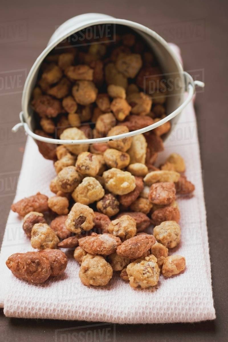 Mixed nuts to nibble in and in front of white bucket Stock Photo