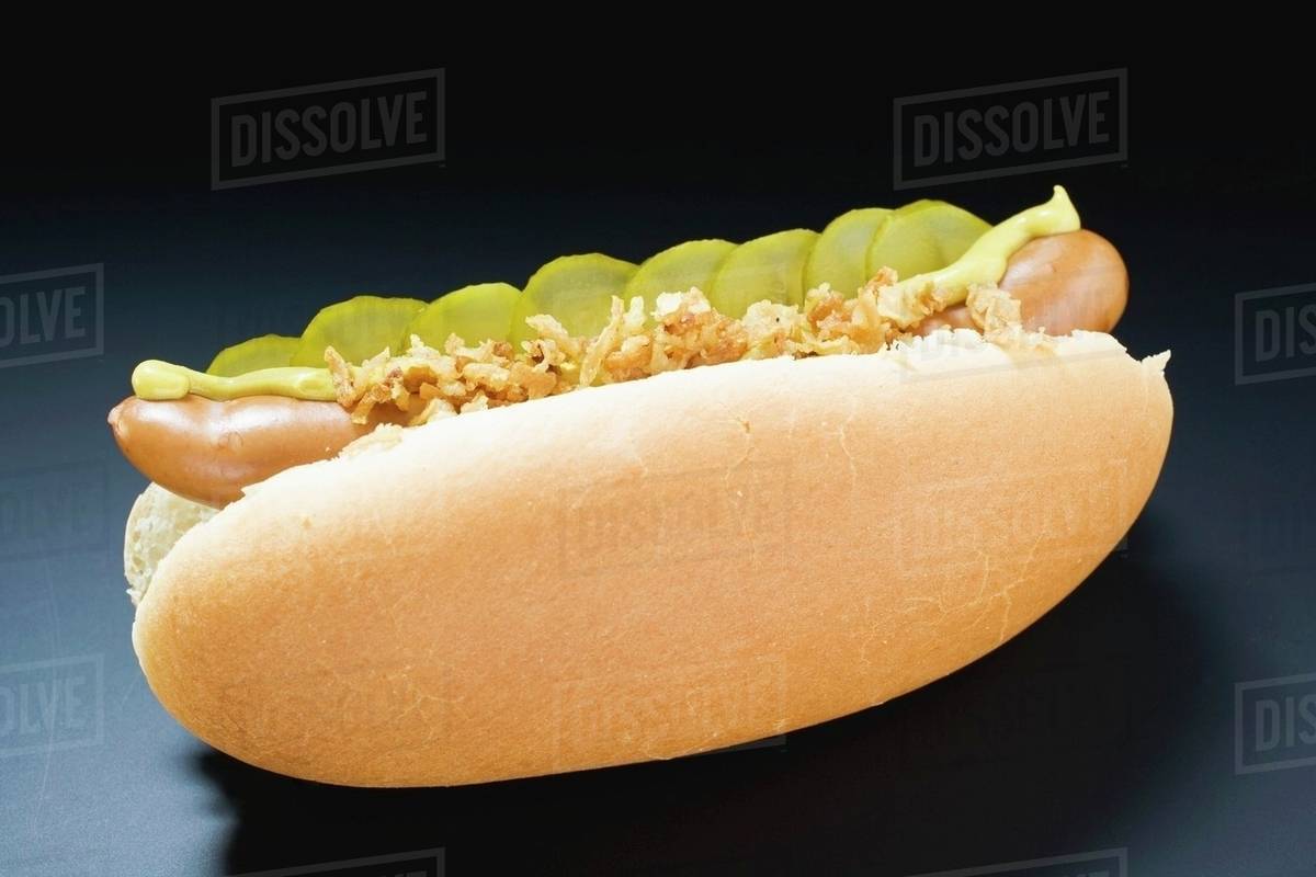 Hot dog with gherkins, fried onions and mustard Stock Photo Dissolve
