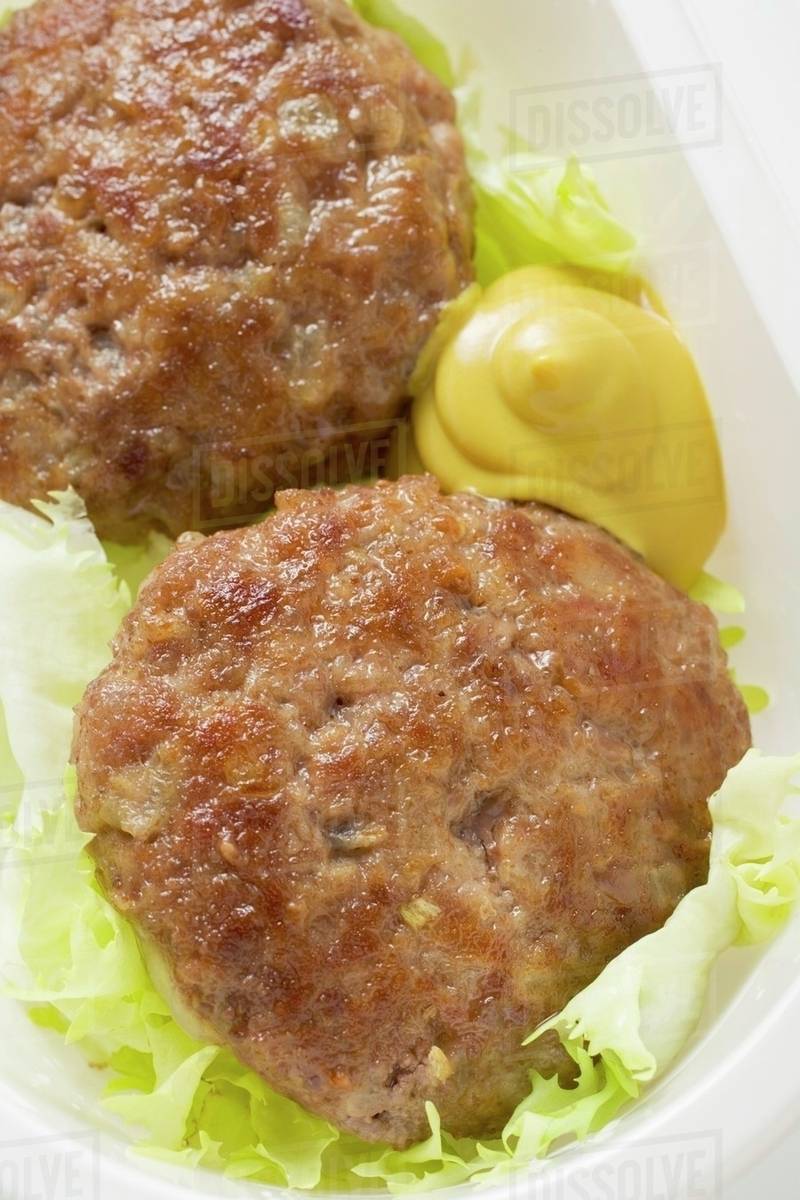 Burgers with mustard and lettuce garnish Stock Photo Dissolve