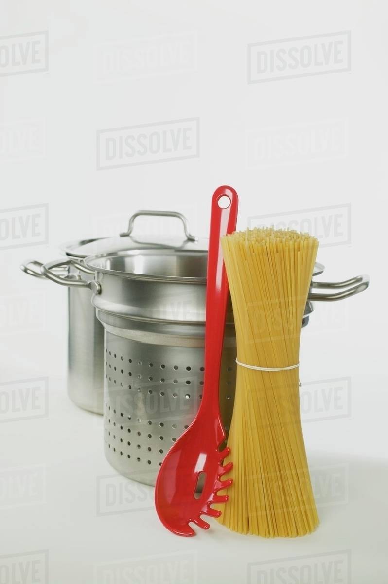 Spaghetti, pans and spaghetti server Stock Photo Dissolve