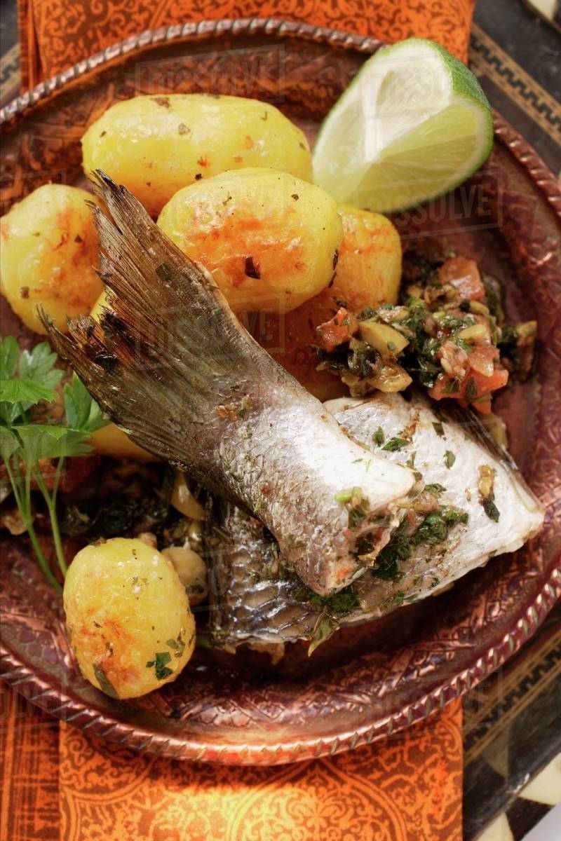Sea bass with roast potatoes (Morocco) Stock Photo Dissolve