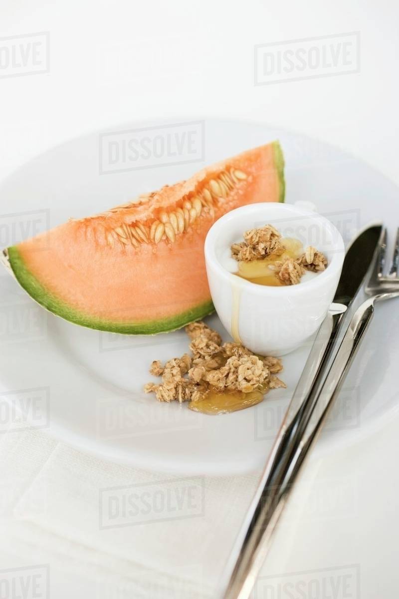Yoghurt with muesli, honey and melon Stock Photo Dissolve