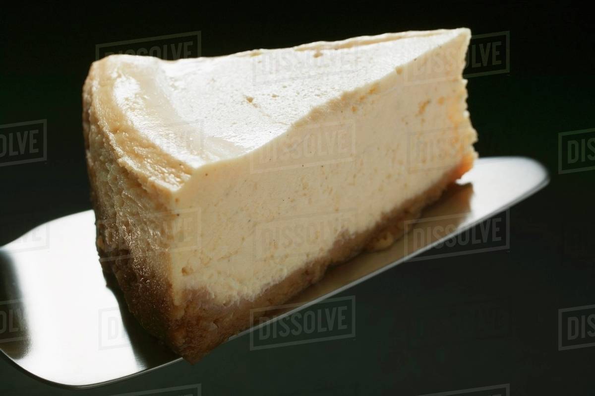 Slice of cheesecake on cake server Stock Photo Dissolve