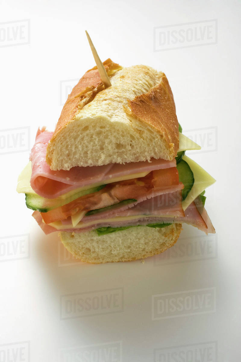 Baguette with ham, cheese, tomato, cucumber with toothpick Stock