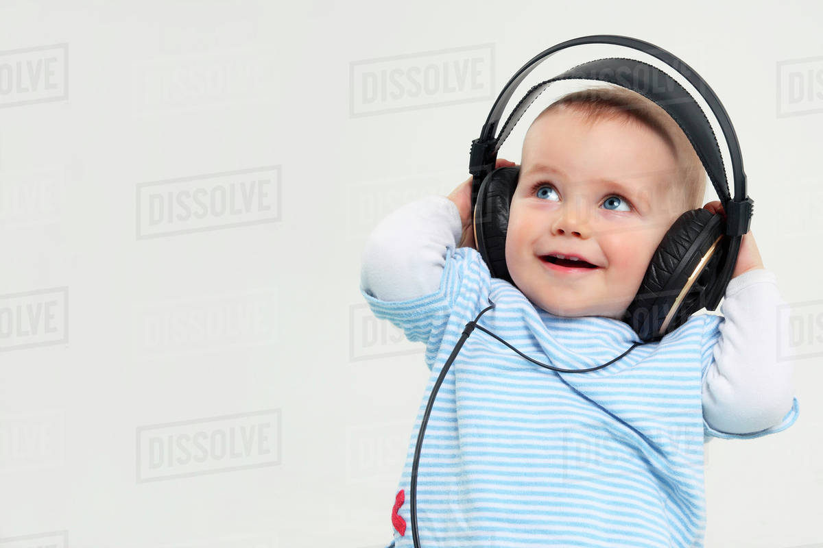 Baby boy with headphones, smiling Stock Photo Dissolve
