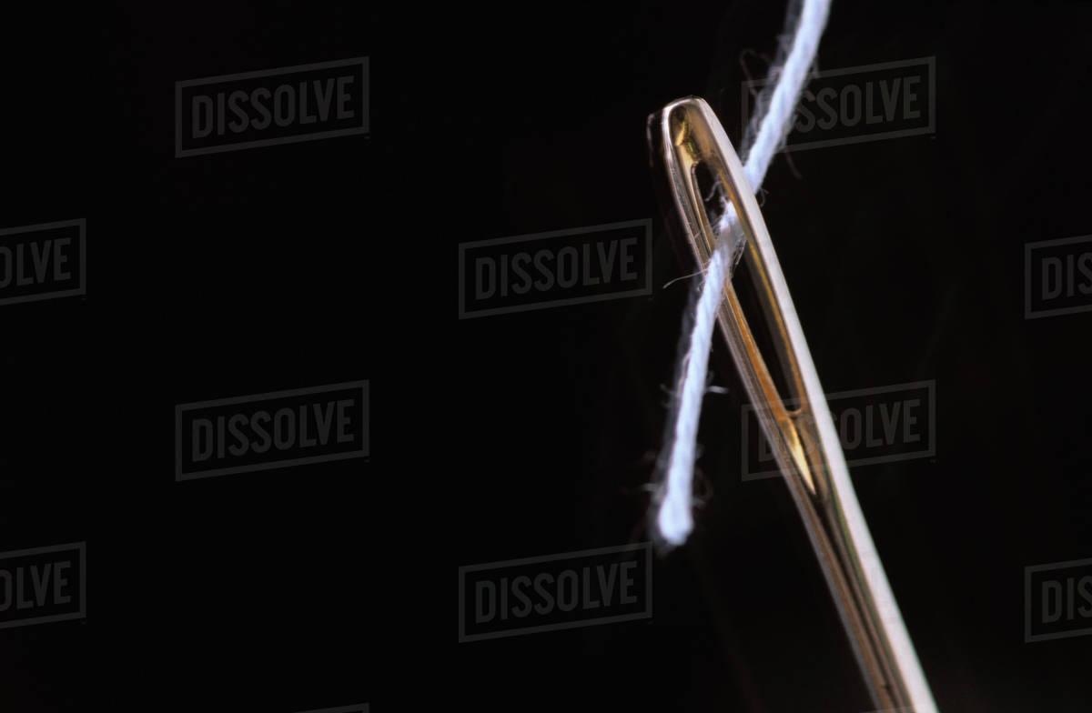 Threaded needle, extreme close up Stock Photo Dissolve