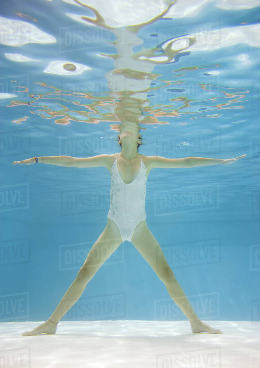 Teenage girl standing spreadeagled in pool, underwater view Royalty-free stock photo