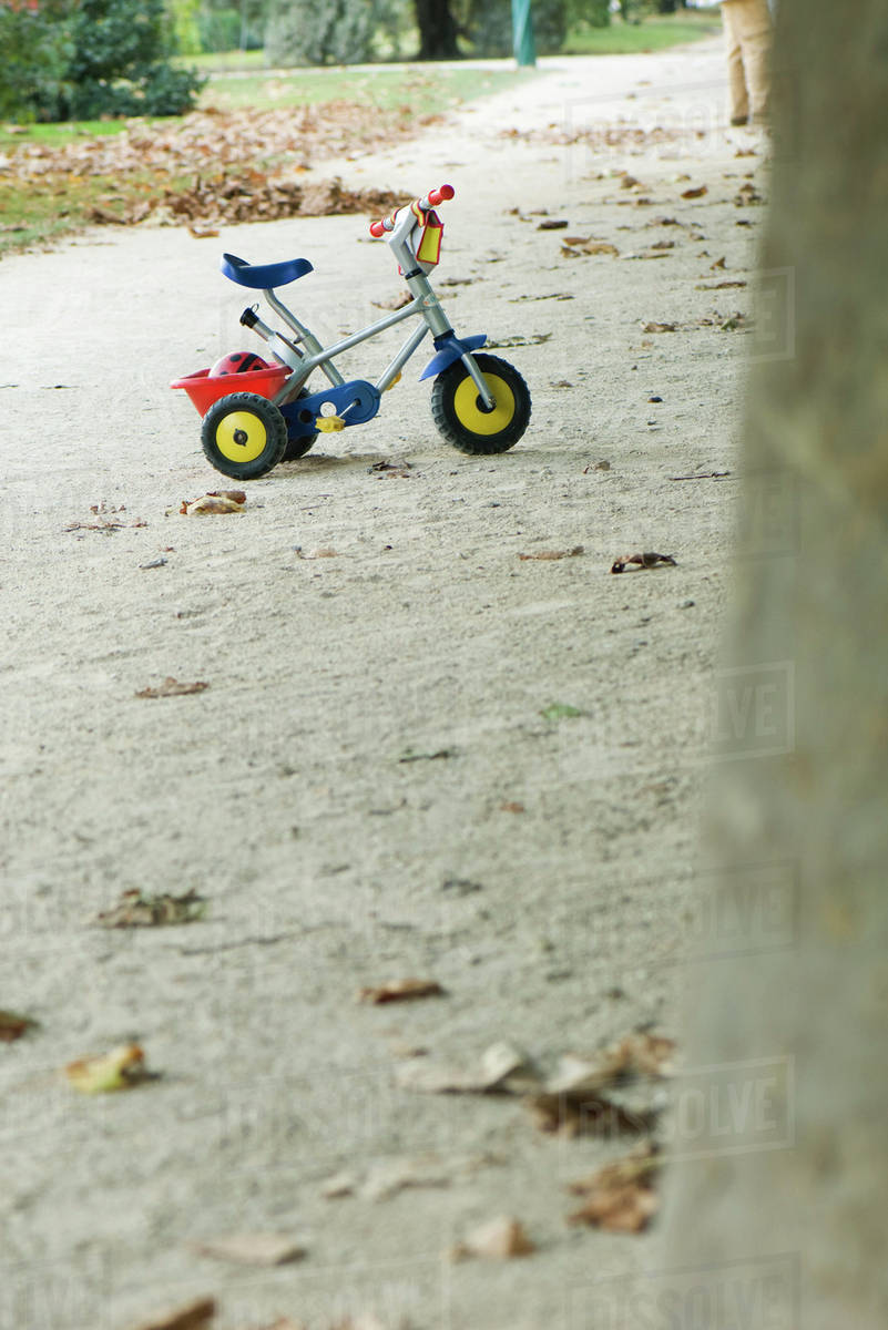 Child's tricycle on gravel path Stock Photo Dissolve