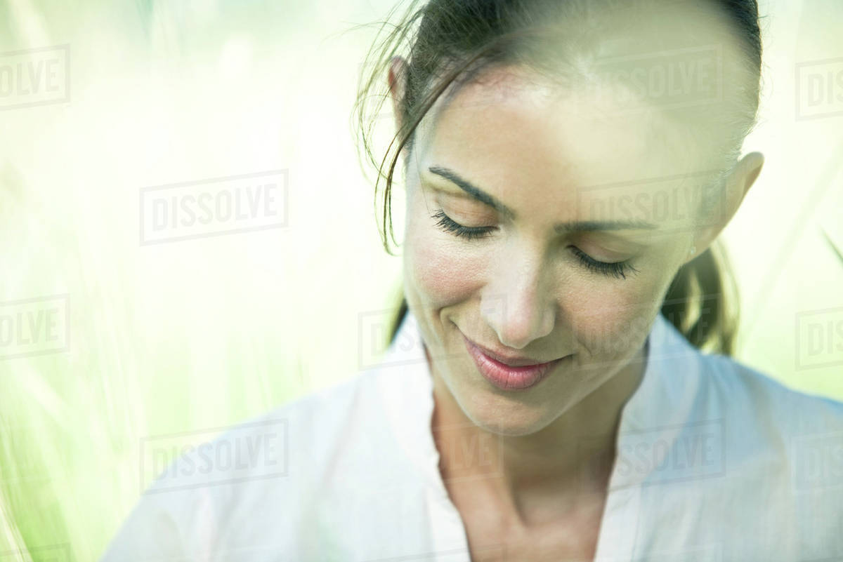 Woman in field, looking down, portrait Royalty-free stock photo