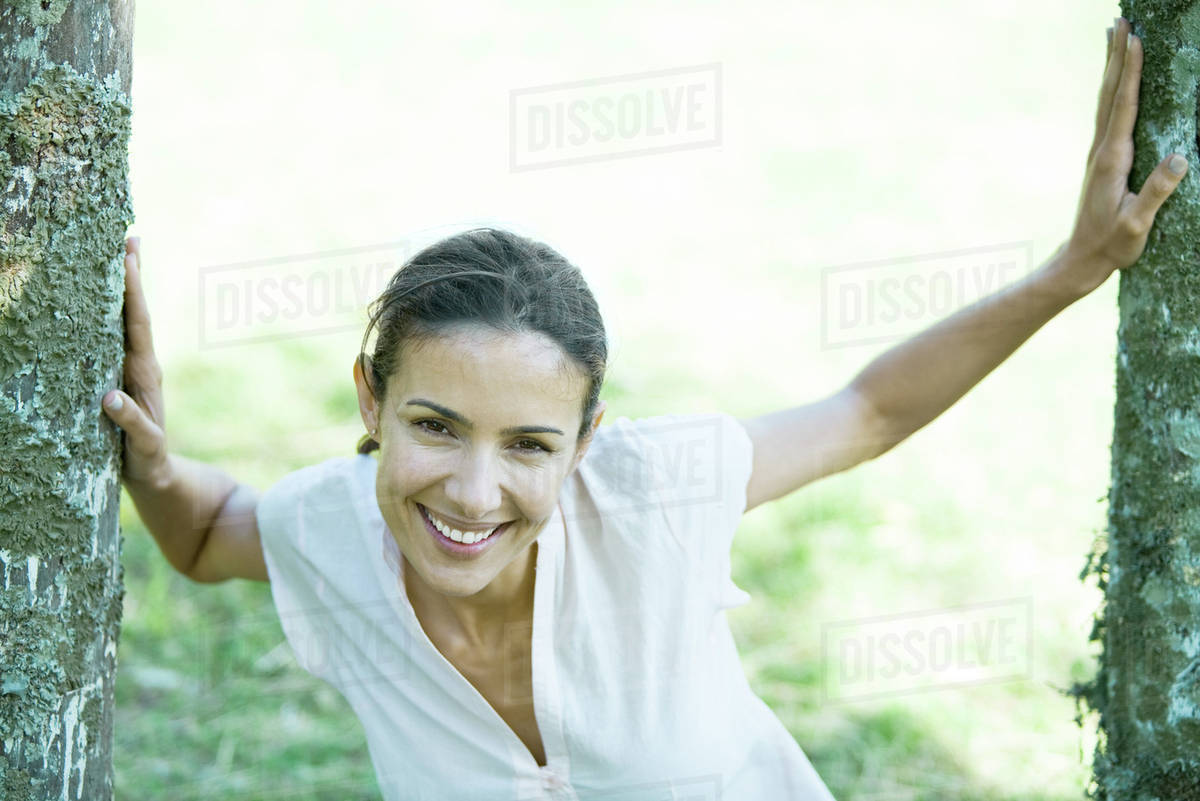 Woman standing between wooden posts, smiling at camera Royalty-free stock photo