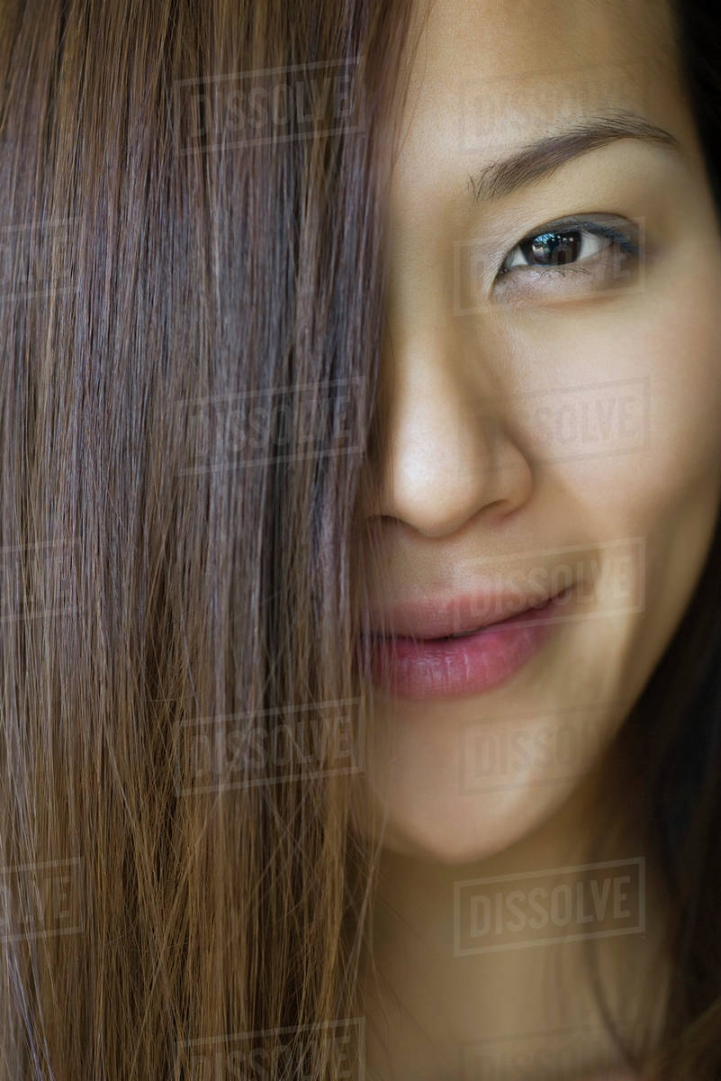 Young woman with hair covering half of face Stock Photo Dissolve
