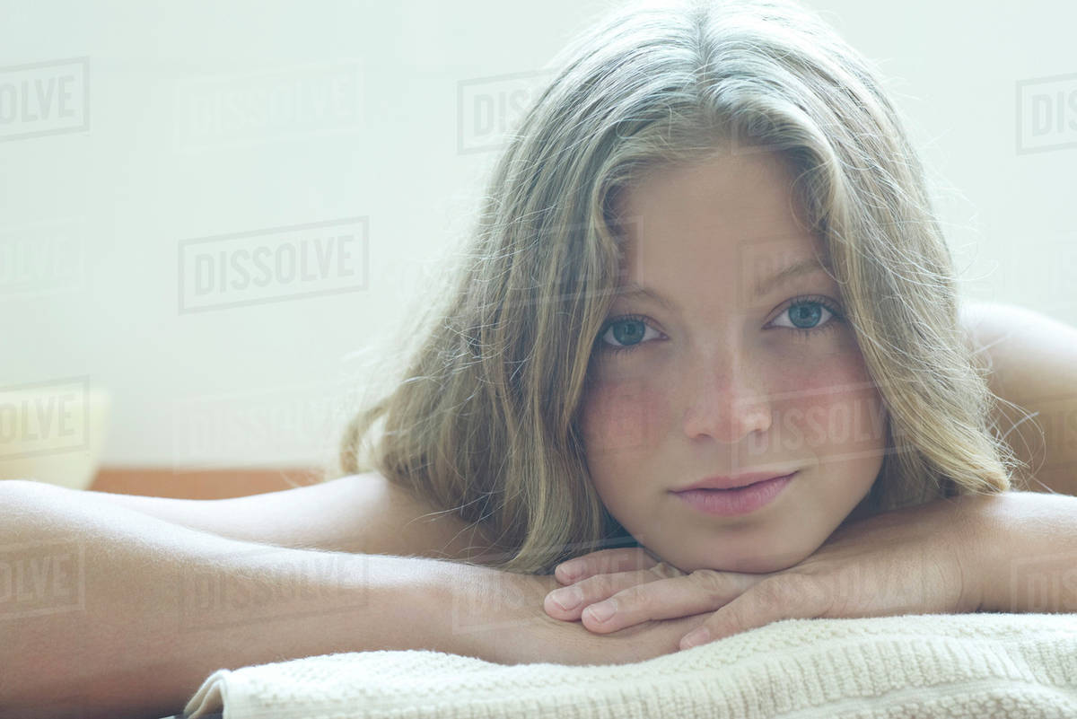 Young woman resting head on arms, portrait Stock Photo Dissolve