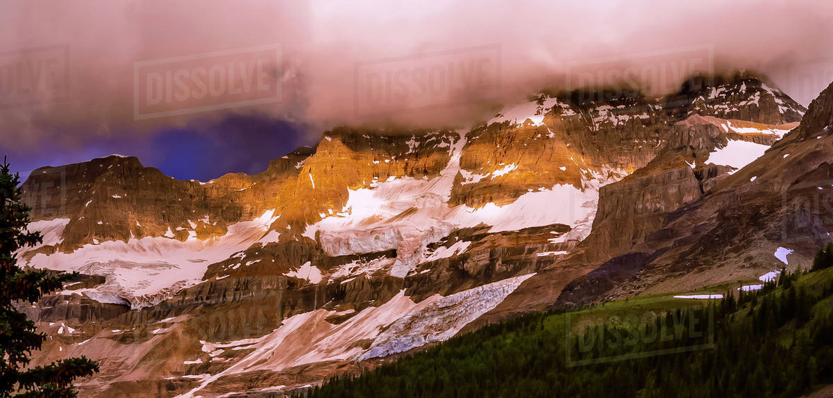 Sunlight and thick clouds over a snowy mountain Royalty-free stock photo