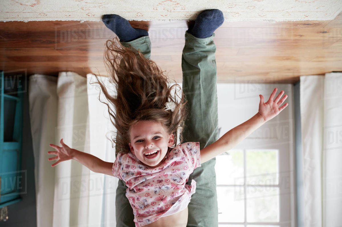 Flipped shot of girl being held upside down by her dad Stock Photo