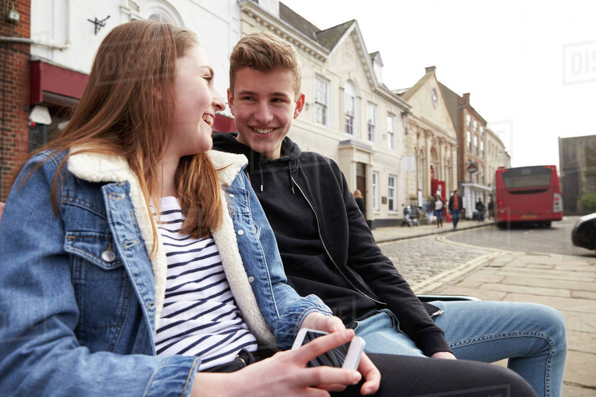 Teenage couple hanging out together in urban setting Stock Photo Dissolve