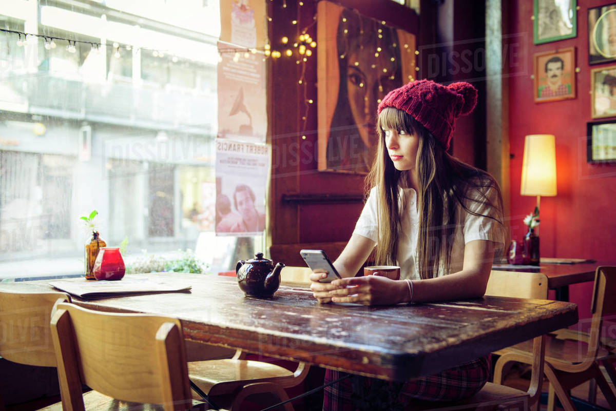 A young woman sitting at a table in a coffee shop in Manchester Royalty-free stock photo