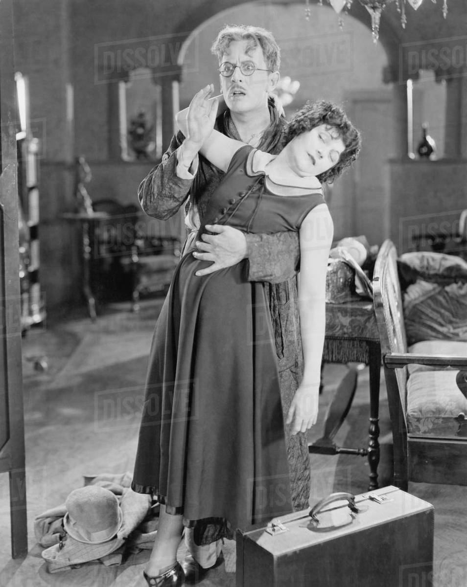 Frightened man supporting fainting woman Stock Photo Dissolve