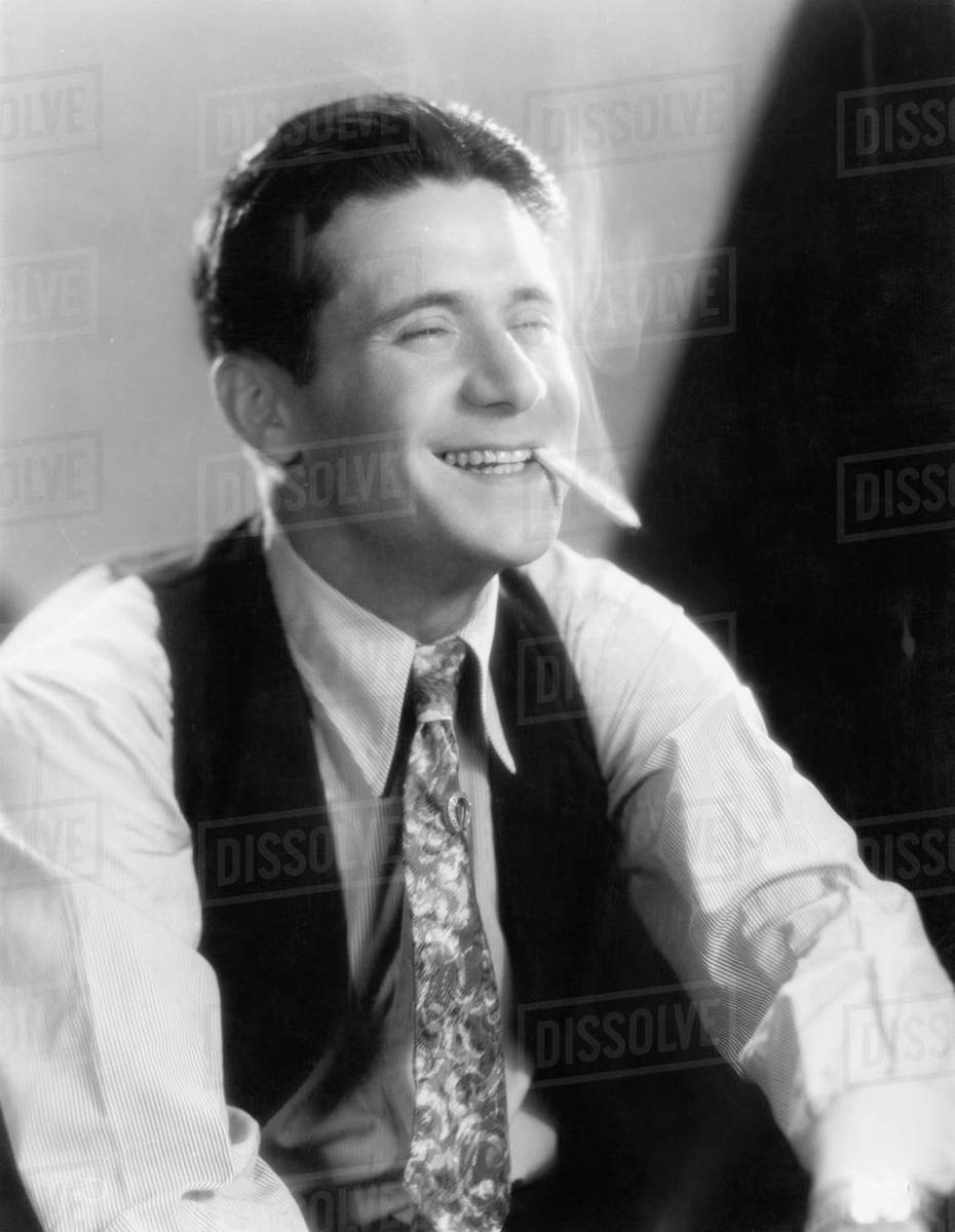 Young man laughing and smoking a cigarette - Royalty-free Stock Photo