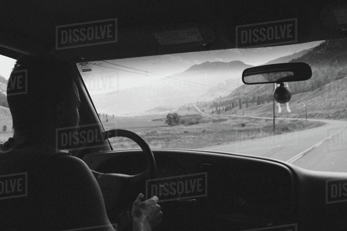 Man driving car on road passing by mountain, Okanagan, British Columbia, Canada Royalty-free stock photo