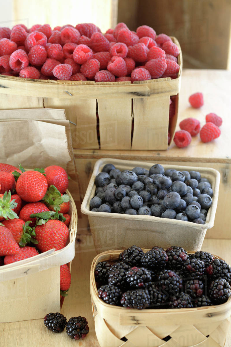 Various fresh berries in baskets Stock Photo Dissolve