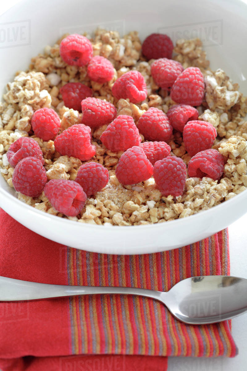 Fresh raspberries in bowl granola cereal Stock Photo Dissolve