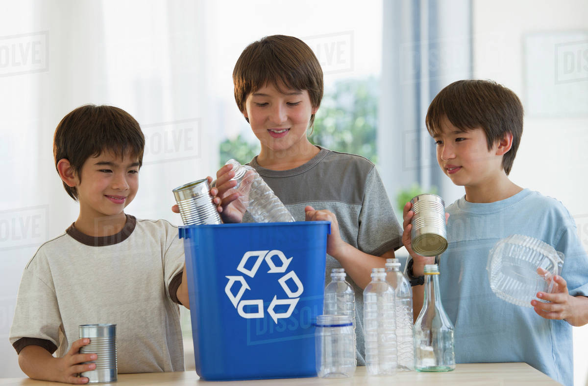 Mixed race brothers recycling plastic bottles and tin cans Stock