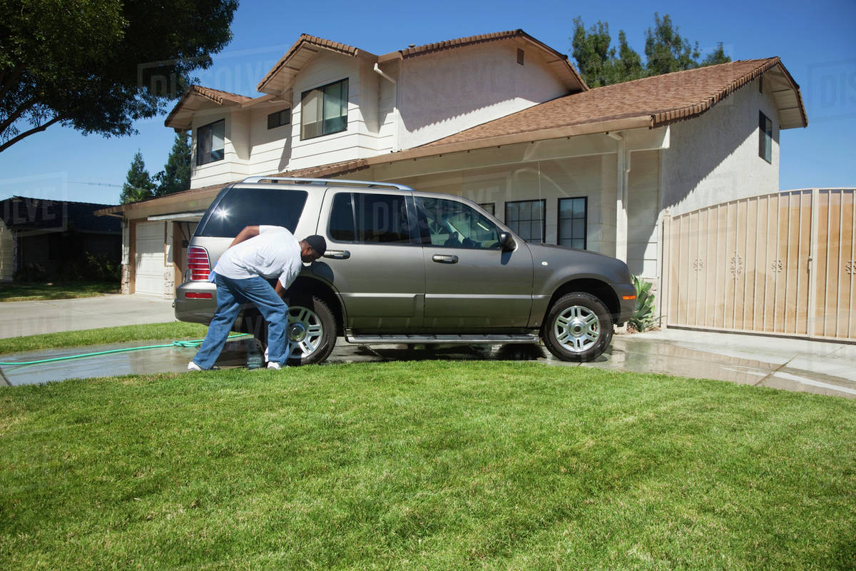 Black man washing car in driveway Stock Photo Dissolve