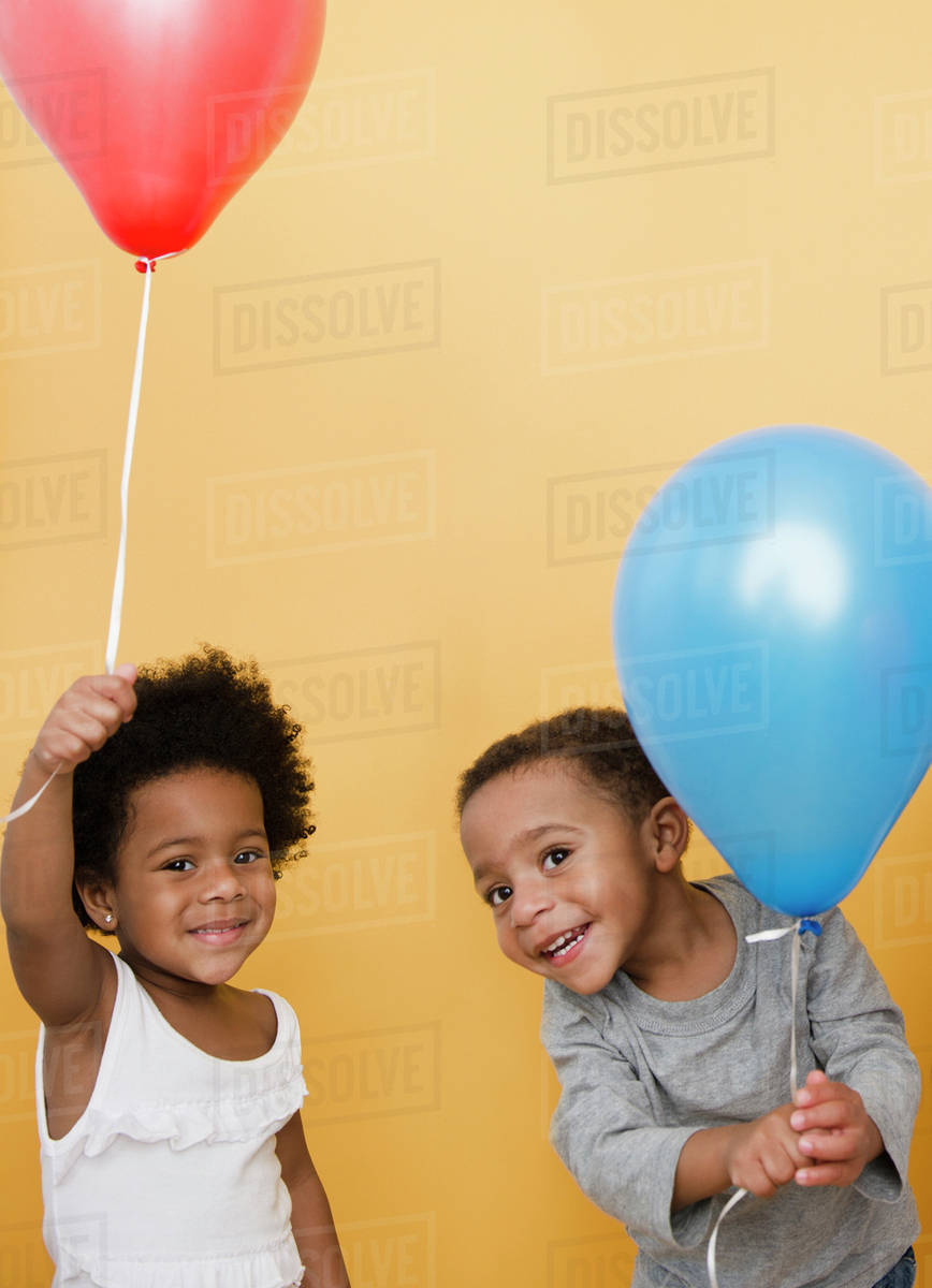 Black children holding helium balloons Stock Photo Dissolve