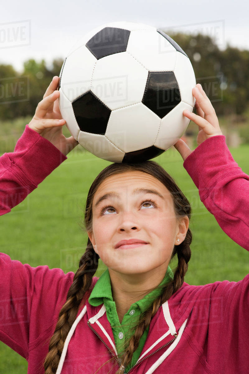 Girl balancing soccer ball on her head Stock Photo Dissolve