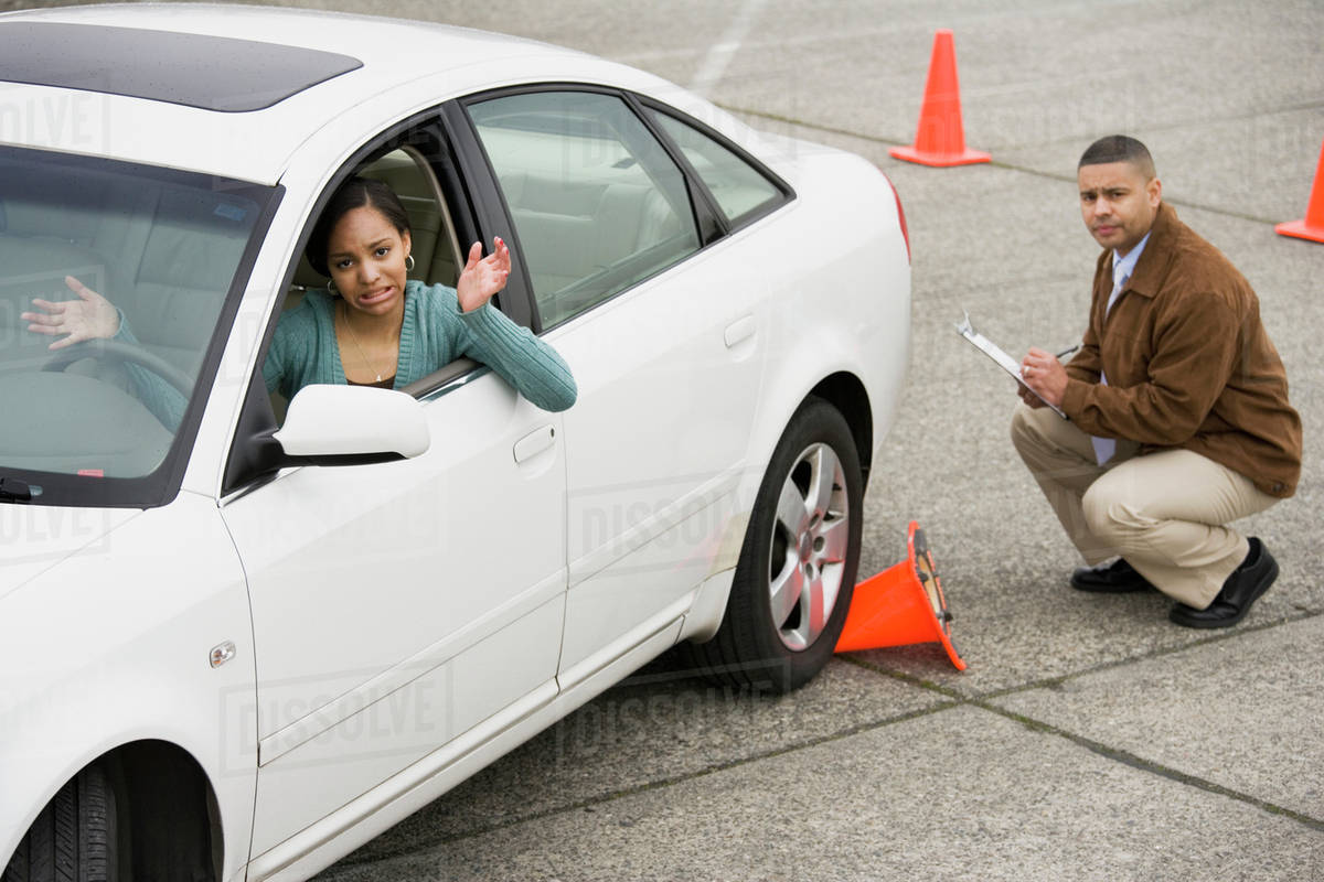 African teenager running over traffic cone at drivers test Stock