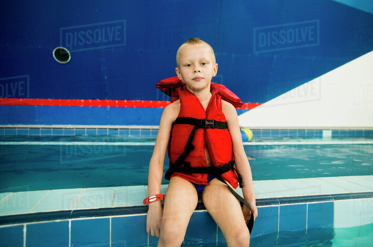 Caucasian boy wearing lifejacket at swimming pool Stock Photo Dissolve