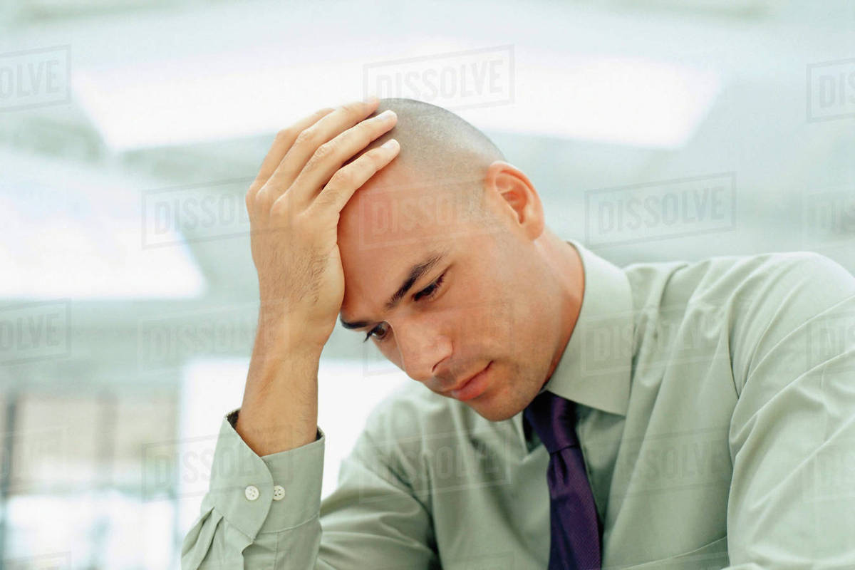 Black businessman rubbing his head Stock Photo Dissolve