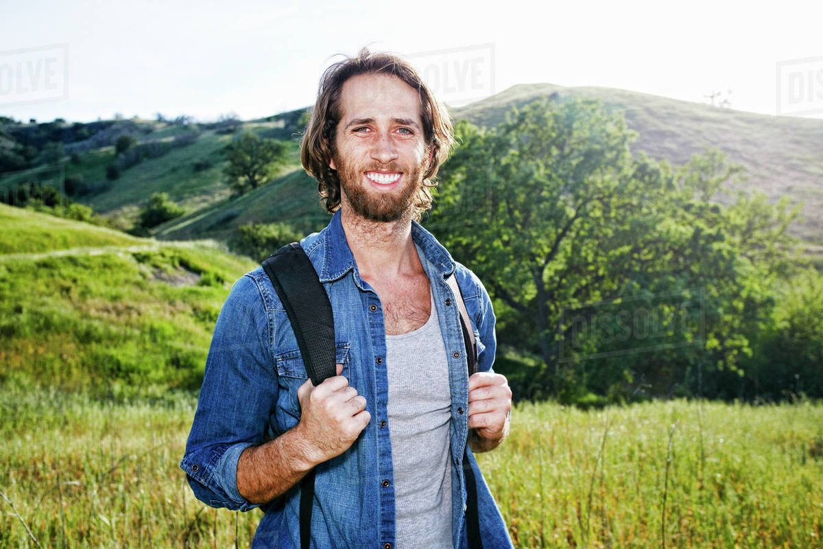 Caucasian hiker standing in grass on mountain Stock Photo Dissolve