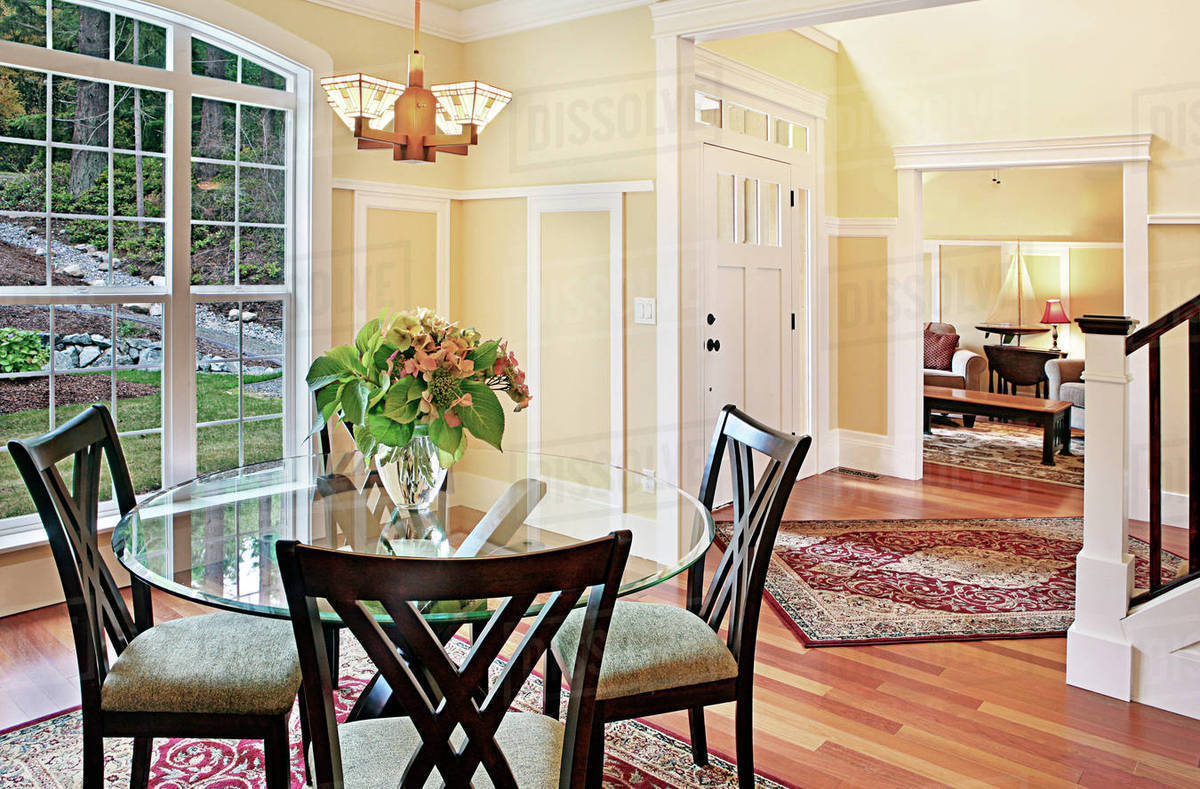 Dining table and chairs near staircase Stock Photo Dissolve